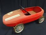 a red pedal car with a steering and a steering wheel