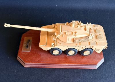 une petite maquette de char d'assaut posée sur un socle en bois