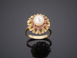 a gold ring with a pearl and ruby stones