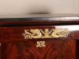 a wooden cabinet with a black top and gold decorations