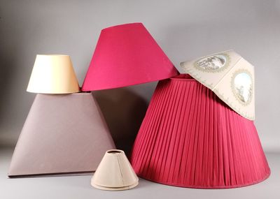 trois lampes de teintes différentes posées sur une surface blanche, avec un abat-jour rose