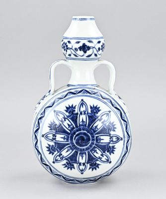 vase bleu et blanc orné d'un motif floral sur le fond