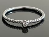 a close up of a silver ring with a diamond on it
