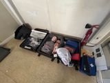 Plusieurs valises sont alignées sur le sol dans une pièce