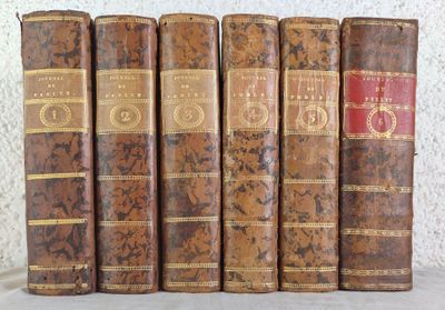 several old books are lined up in a row on a table