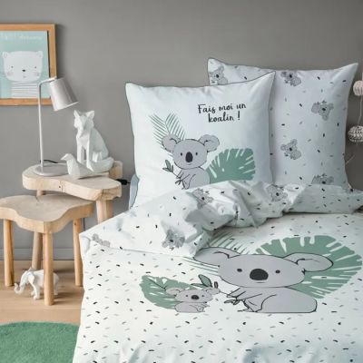 un lit avec une couette blanche ornée d'un motif de koala