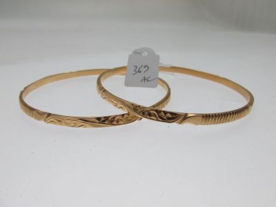 deux bracelets rigides en or ornés de motifs gravés et accompagnés d'une étiquette de prix