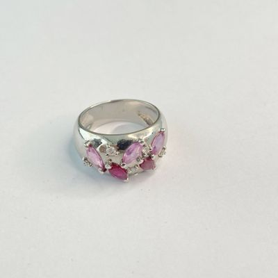 un gros plan d'une bague rose et blanche posée sur une surface blanche