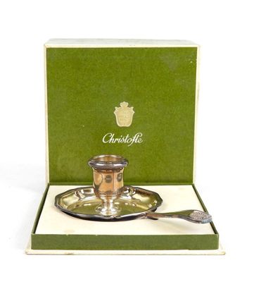 une tasse et une soucoupe en argent dans une boîte avec une cuillère