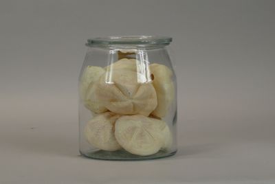 a glass jar filled with peeled bananas on a white surface