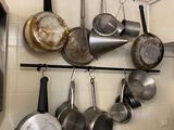 pots and pans hanging on a wall in a kitchen