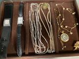 a wooden box with a watch, bracelets, and other jewelry