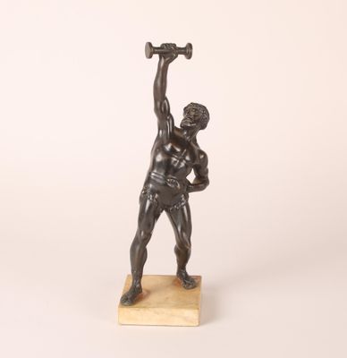 an image of a bronze statue of a man holding a hammer