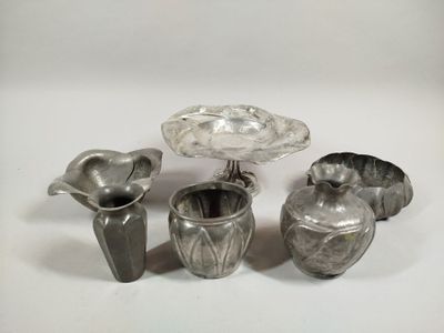 a group of silver vases sitting on a white surface