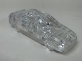 a clear plastic toy car on a white surface