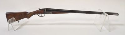 le fusil est posé sur un support transparent, sur une surface blanche