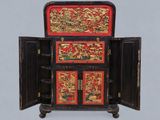 a black cabinet with a red and gold design on it