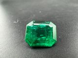 a close up of a green emerald stone on a black surface