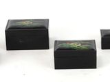 several small black boxes with green plants on them on a white surface