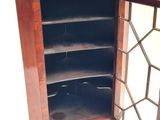 a wooden cabinet with a glass door and shelves