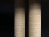 two round wooden tables sitting on top of a black surface