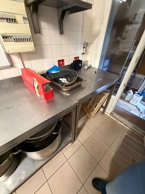 Il y a quelqu'un dans la cuisine avec une casserole et une poêle posées sur le plan de travail.