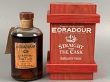 une bouteille de whisky posée à côté d'une caisse en bois