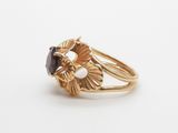 a close up of a gold ring with a black stone