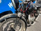 une moto garée à côté d'une camionnette sur laquelle on voit des graffitis sur le côté
