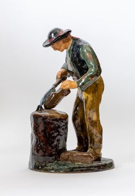 figurine représentant un homme versant de l'eau d'un seau, sur fond blanc