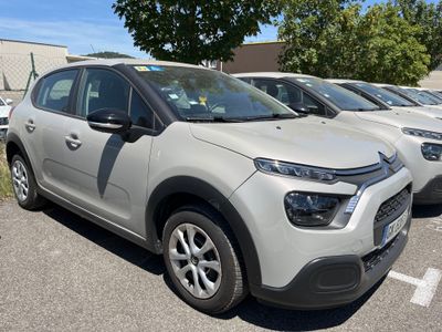 de nombreuses voitures garées sur un parking, avec des arbres en arrière-plan