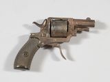 un petit pistolet posé sur une surface blanche