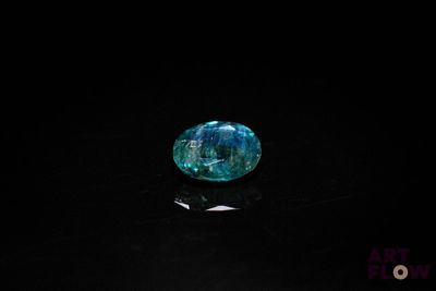 a close up of a blue stone on a black surface
