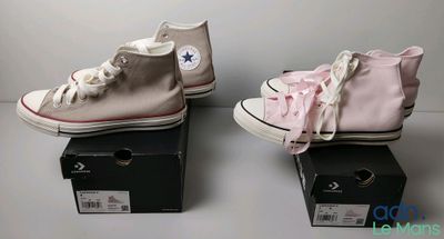deux paires de Converse roses et blanches posées sur une boîte noire