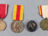 three medals and a medal on a gray surface