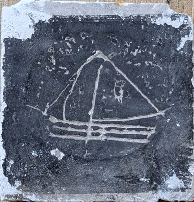 une photo d'une pierre sur laquelle est représenté un bateau
