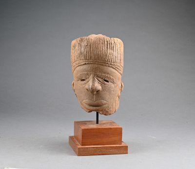 sculpture représentant une tête d'homme, posée sur un socle en bois