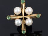 a close up of a gold ring with pearls and emeralds