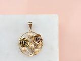 pendentif en or jaune rose posé sur un bloc de marbre blanc