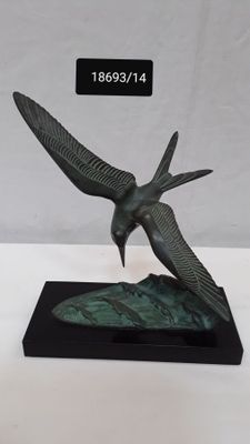 statue of a bird on a black base with a white background