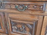 a wooden cabinet with carvings on the top of it