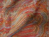 a close up of a red, orange, and blue paisley print scarf