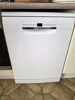 un lave-vaisselle dans une cuisine où se trouve un saladier rempli de nourriture sur le plan de travail