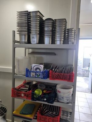 une cuisine où les étagères sont remplies de vaisselle et de casseroles