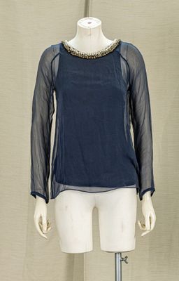 a mannequin with a blue top on a mannequin stand