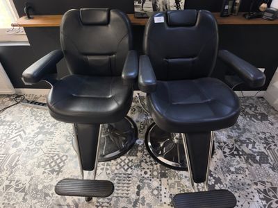 deux fauteuils inclinables en cuir noir, disposés comme dans un salon