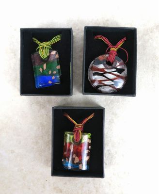 trois petites boules de Noël en verre dans une boîte noire posée sur une surface blanche