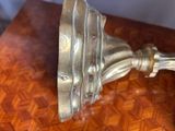 a silver vase on a wooden table with a brown table cloth