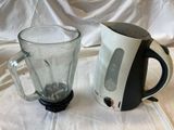 a blender next to a glass of water on a table