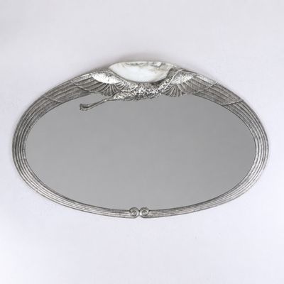 an image of a mirror with a bird on it on a white surface